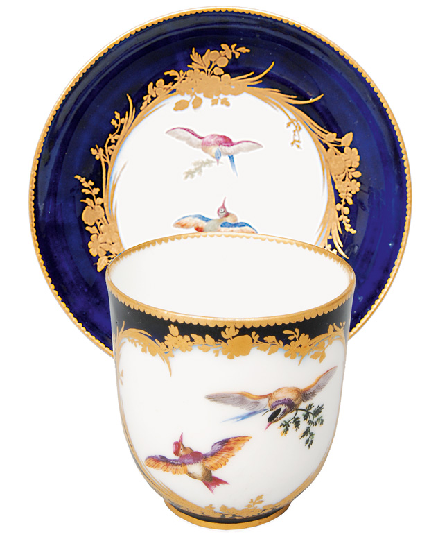 A cobalt blue cup with painting of birds