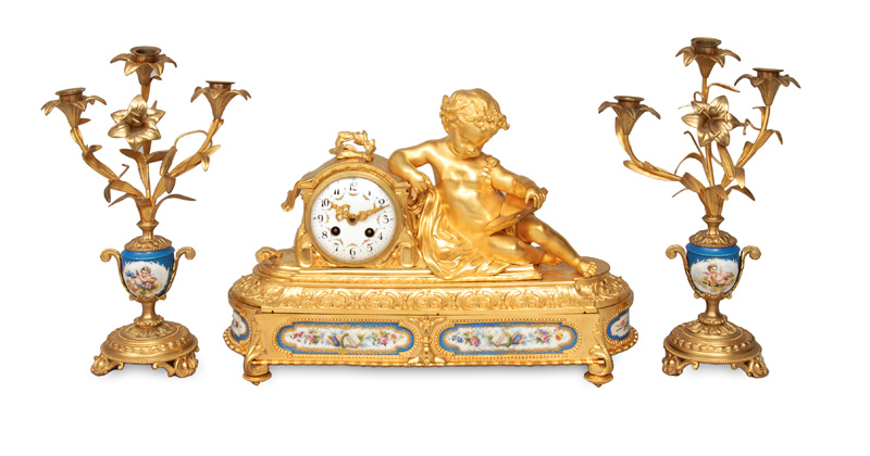 A Napoleon III fireplace mantle clock with a pair of candle holders