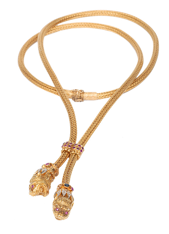 A long golden necklace with lions heads by Ilias Lalaounis