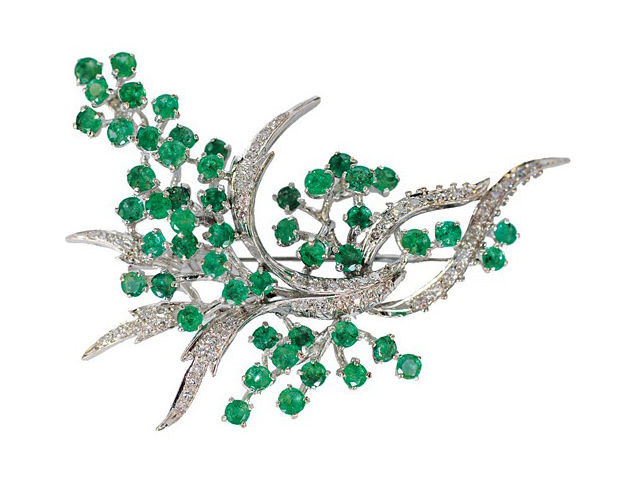 A large emerald diamond brooch