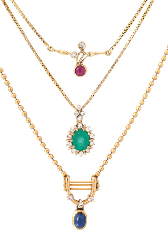 Three golden necklaces with small precious stone pendants