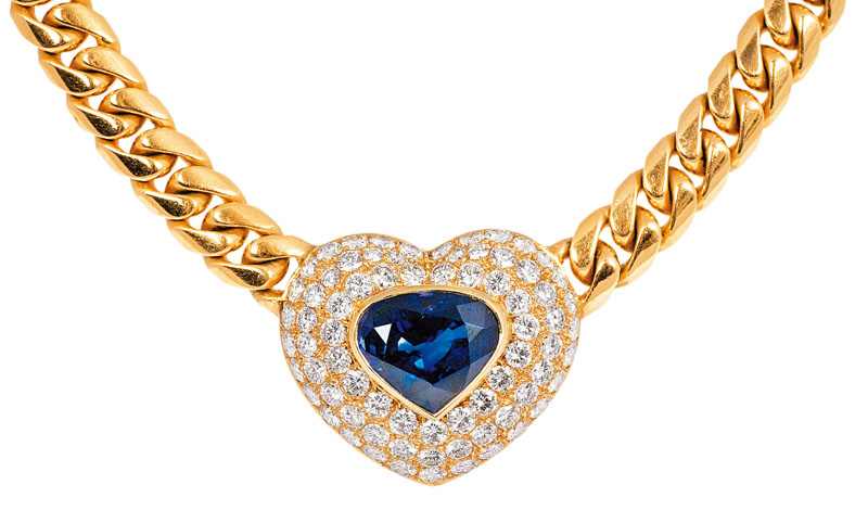 A gold necklace with heartshaped sapphire diamond pendant