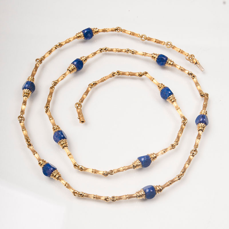 A long golden necklace with lapis lazuli