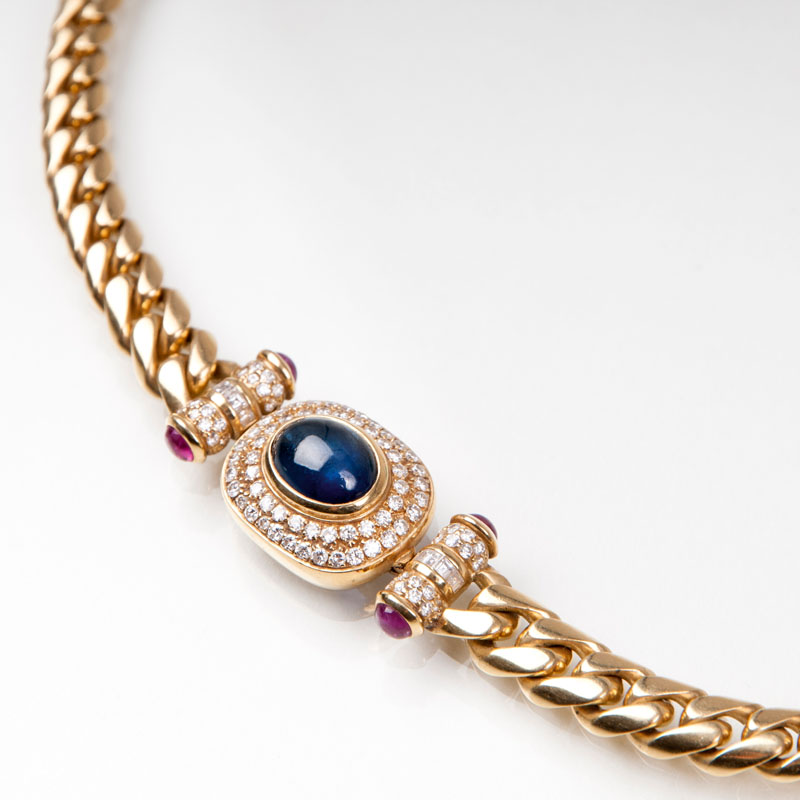 A golden necklace with a sapphire cabochon, rubies and diamonds