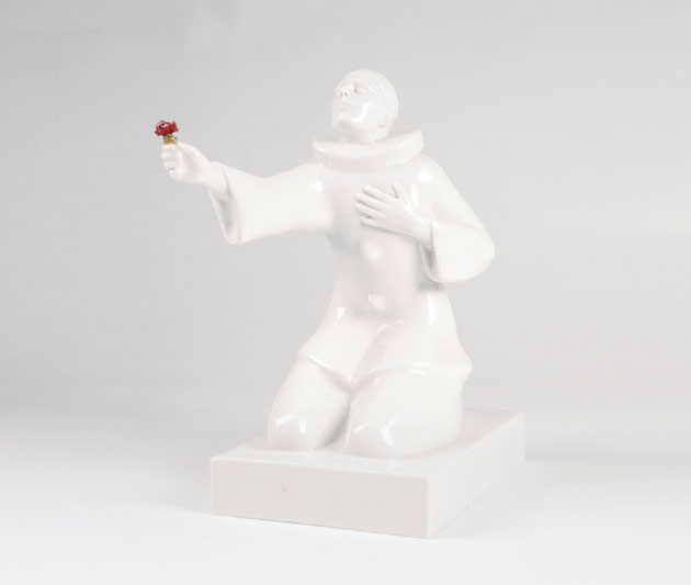 A porcelain figure 'kneeling harlequin with flower bouquet'