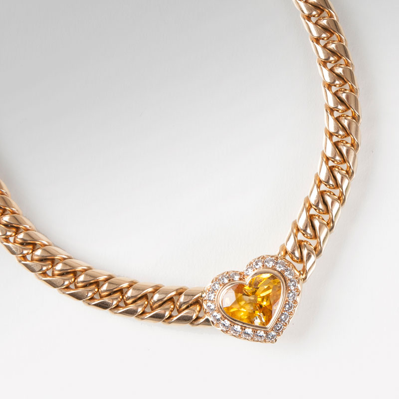 A high-grade gold necklace with one yellow sapphire in heart shape and diamonds