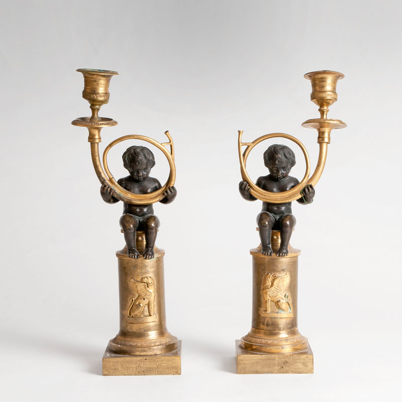 A pair of Napoleon III bronze candlesticks with putti