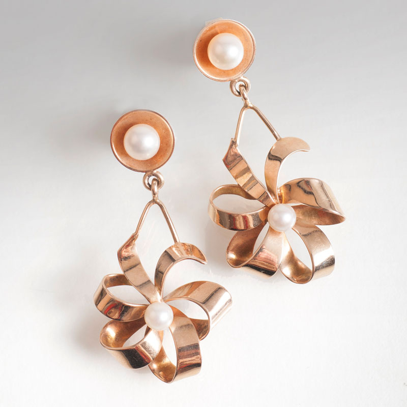 A pair of gold earrings in flowershape with pearls