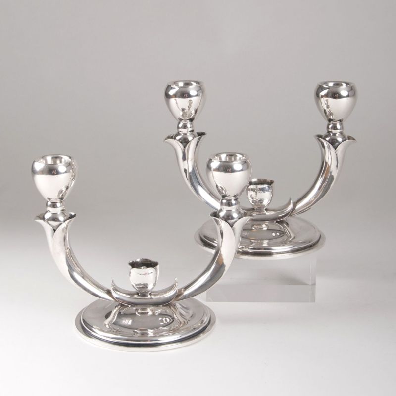 A pair of candleholders with stylized flower decor