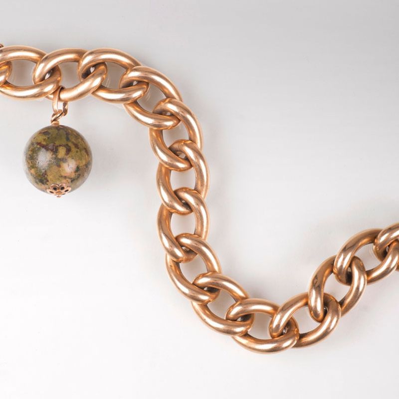 A gold bracelet with spherical pendant