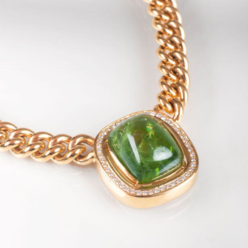 A classical curb chain necklace with a large peridot diamond pendant