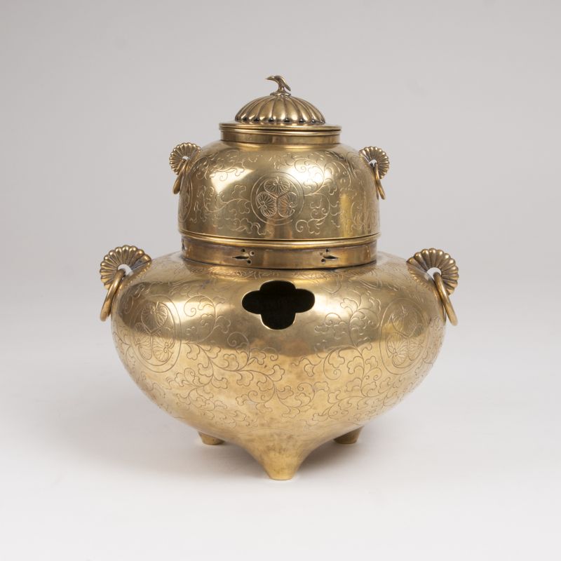 A brass incense burner with engravings