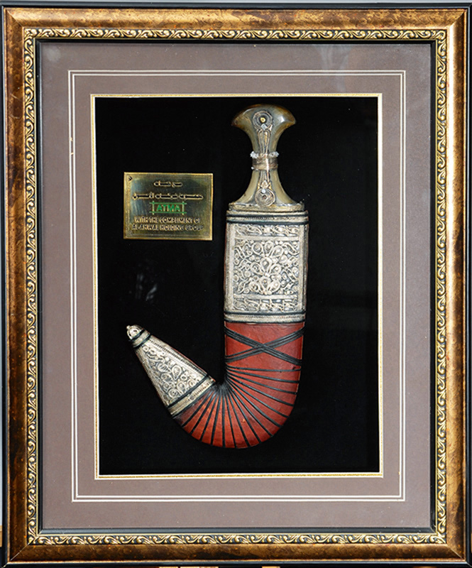 An oriental curved dagger in glass frame