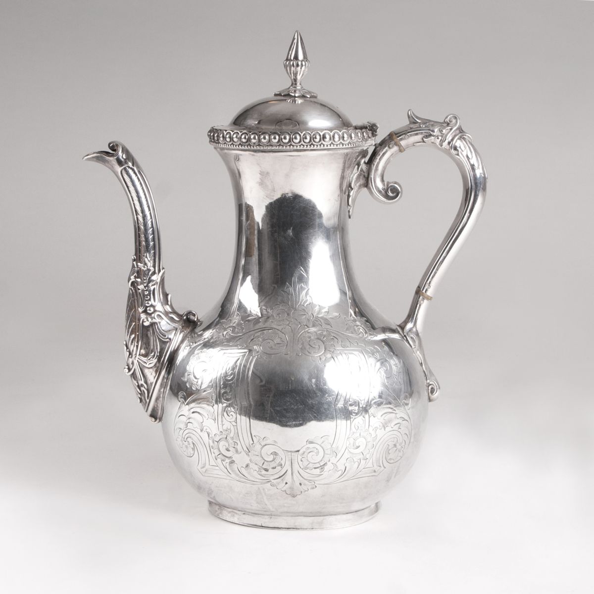 A coffee pot with flower engravings