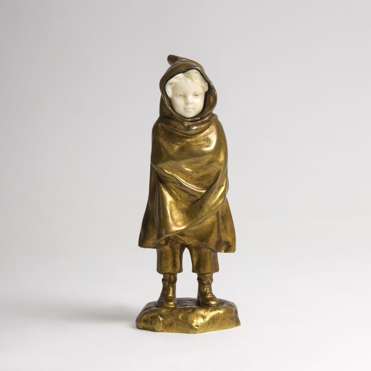 A bronze figure 'Child with cape and hood'