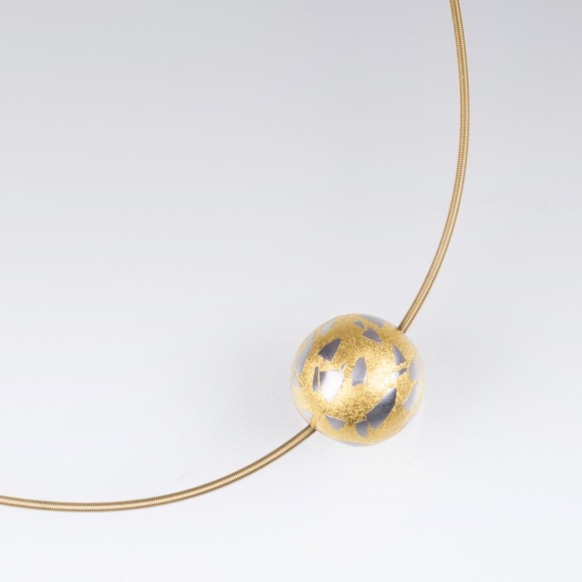 A platinum gold ball pendant with golden necklace
