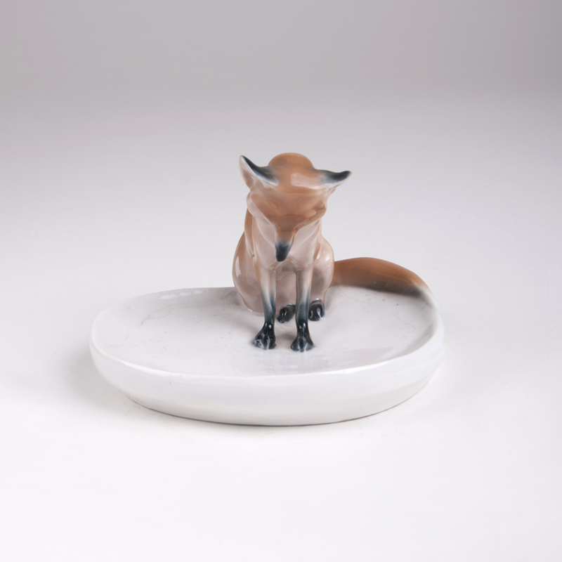 'Seated fox on a bowl'