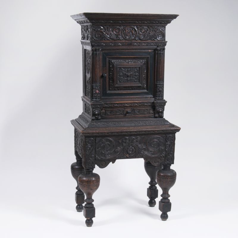 A small Renaissance cabinet with a rich wood carving
