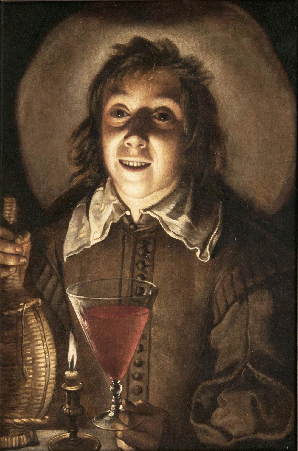 Junger Mann mit Weinglas im Kerzenlicht