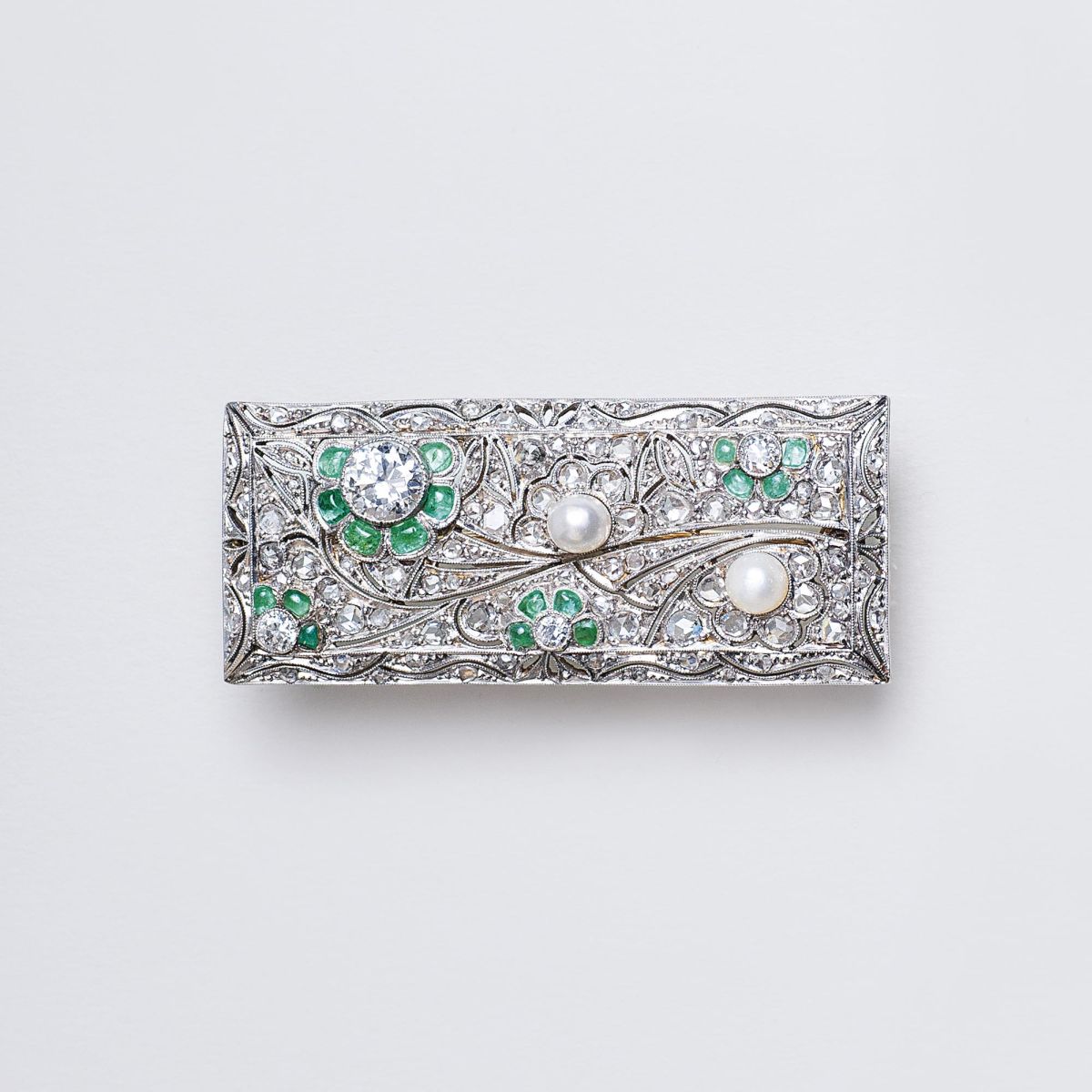 An Art-déco Diamond Brooch with Emeralds and Pearls An Art-déco Diamond Brooch with Emeralds and Pearls