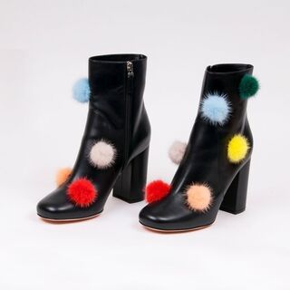 Paar schwarzer Leder Booties Pom Pom