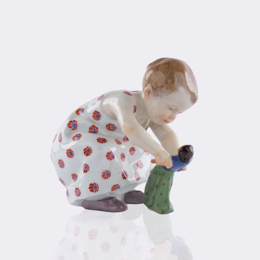 Hockendes Kind mit einer Puppe