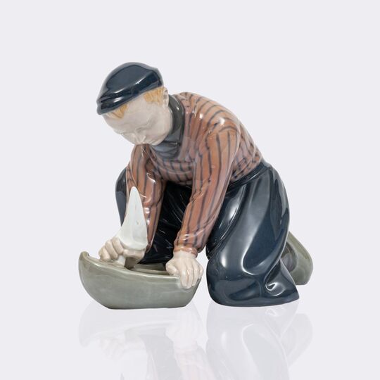 Kniender holländischer Junge mit Segelschiff