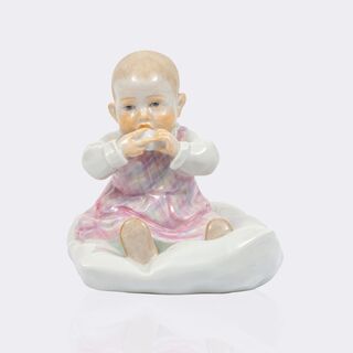 Kind, auf einem Kissen sitzend