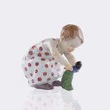 Hockendes Kind mit einer Puppe - Bild 1