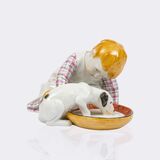 Kind mit Hund, der aus einer Schale säuft