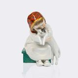 Sitzendes Kind mit einer Katze im Arm