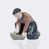 Kniender holländischer Junge mit Segelschiff